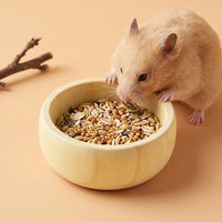Hamster s'alimentant dans une gamelle en bois